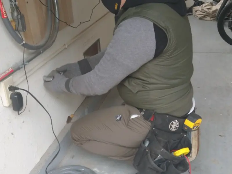 Electrician performing outlet wiring in a Alexandria garage
